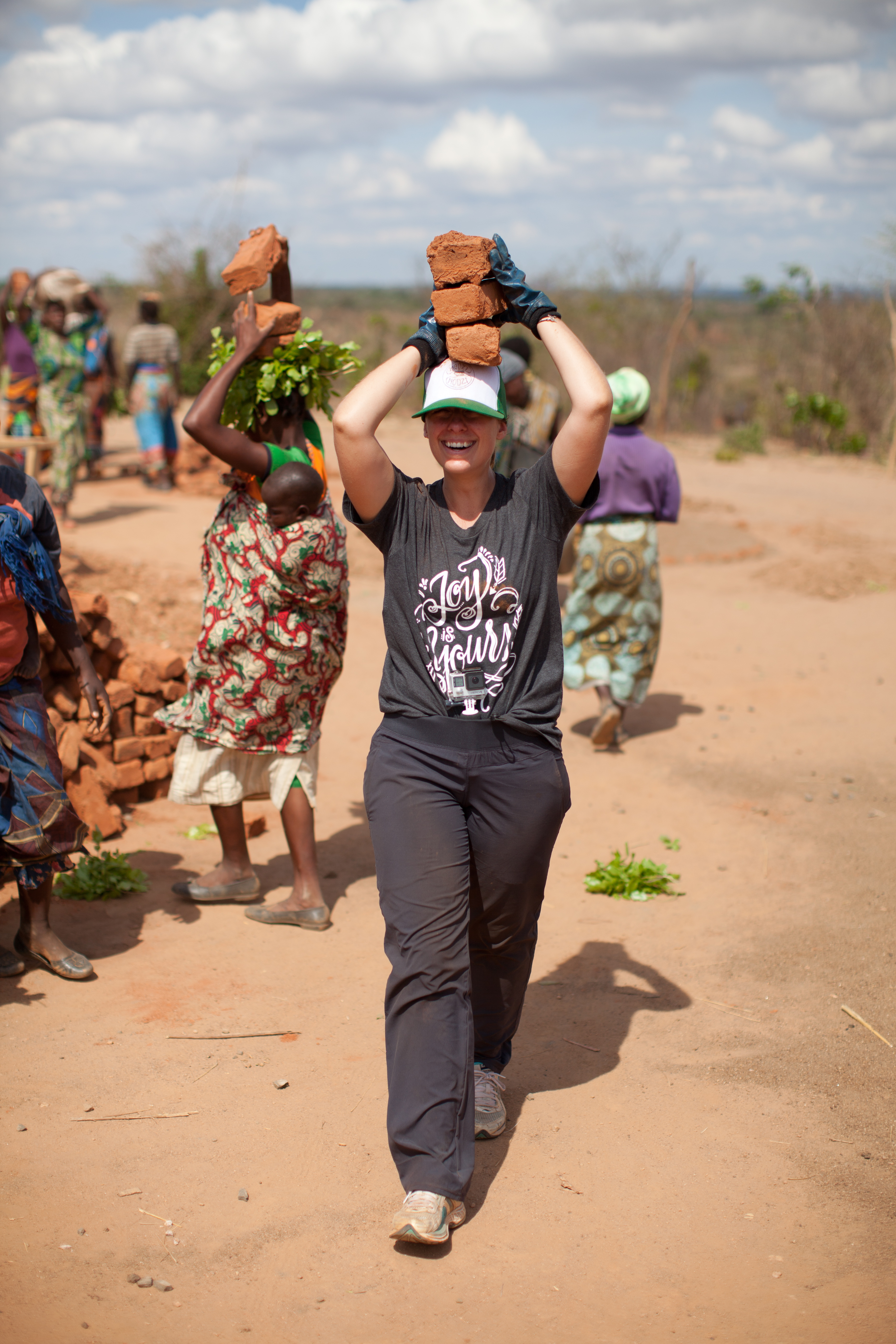 Liz carrying bricks on her head during a trek in Malawi
