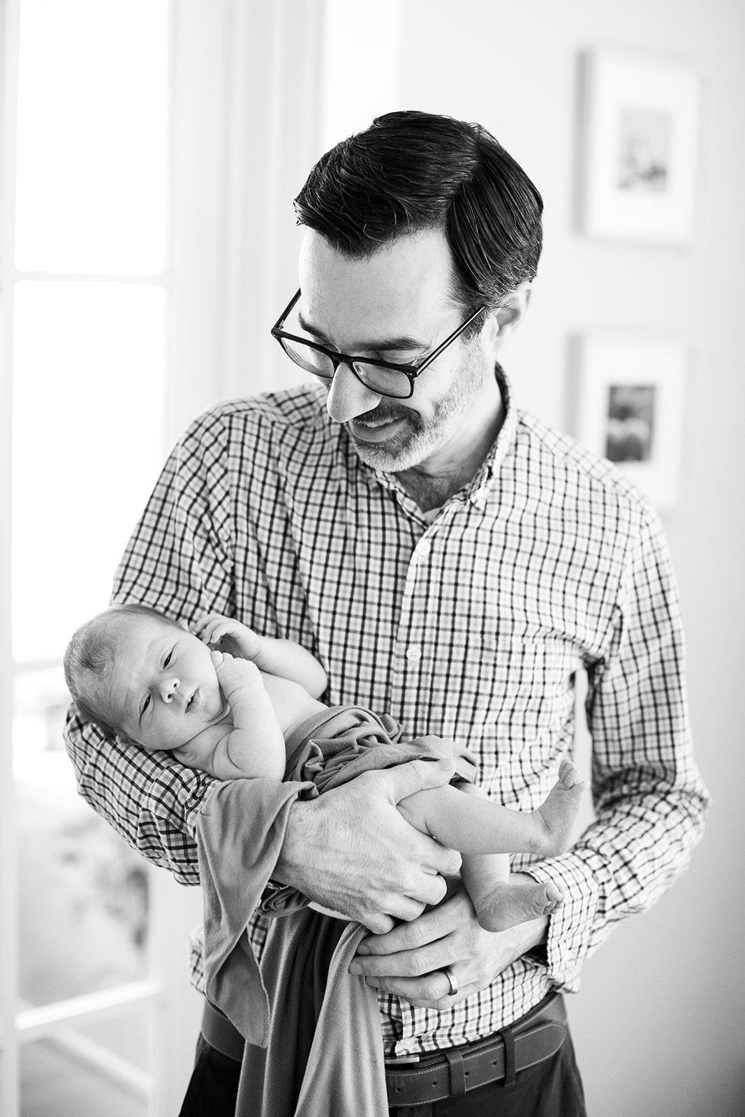 Big brother meeting his newborn sister in black and white